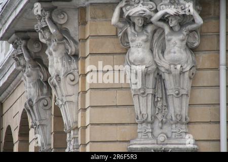 Questa immagine cattura una maestosa scena all'aperto di un edificio con statue di diversi uomini, di cui una in grado di reggerne due Foto Stock