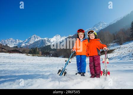 Ragazzo e ragazza alla loro prima fuga alpina in caschi, maschere da sci Foto Stock