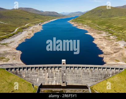 Garve, Scozia, Regno Unito. 9th giugno 2023. Una vista aerea della diga di Glascarnoch a sud di Ullapool. Condizioni di siccità prolungate nelle Highlands scozzesi hanno portato a bassi livelli di acqua nel serbatoio di Glascarnoch vicino a Garve. Le autorità hanno avvertito di possibili restrizioni di acqua se il tempo asciutto continua. Iain Masterton/Alamy Live News Foto Stock