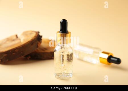 Contenitore per bottiglie cosmetiche naturali con legno su sfondo beige. Rimedio fatto casa e concetto di prodotto di bellezza. Vista dall'alto Foto Stock