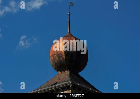 Cupola dorata a cipolla su una delle torri dello Stockalper Palace o Stockalperpalast a Brig, nel Canton Vallese, nella Svizzera alpina meridionale. Il palazzo fu costruito negli anni '1600s da un imprenditore favoloso e ricco, Kaspar von Stockalper, e una volta si diceva che la cupola della cipolla (una delle tre) fosse stata ricoperta d'oro per proclamare le immense ricchezze di Stockalper. Foto Stock