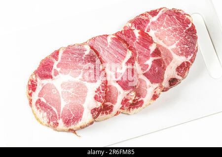 Un trio di tagli di carne freschi e succulenti giacciono su un tagliere bianco fresco Foto Stock