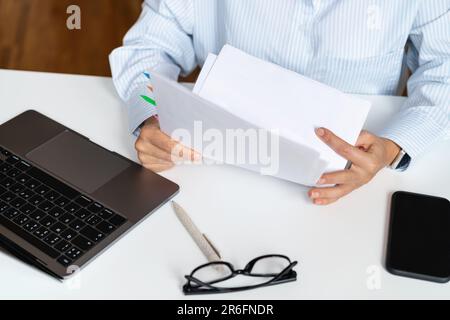 Vista ad alto angolo dei documenti nelle mani del lavoratore del collare bianco, controllo fiscale, contratto di prestito. Foto Stock