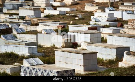 Monastir, Tunisia, 19 gennaio 2023: Siti di sepoltura ricoperti di piastrelle bianche in un cimitero musulmano Foto Stock