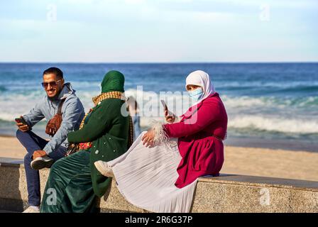 Sousse, Tunisia, 19 gennaio 2023: Famiglia in abito demure tradizionale che copre testa e faccia sul lungomare Foto Stock