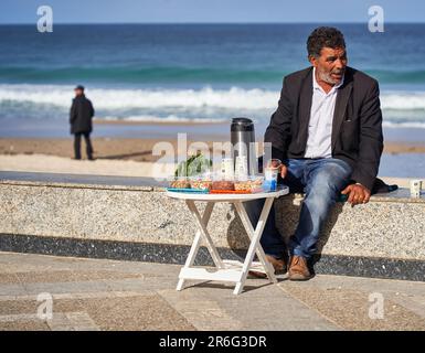 Sousse, Tunisia, 19 gennaio 2023: Un falco sul lungomare di Boujavaarstrand in Tunisia vende tè con noci ai passanti Foto Stock