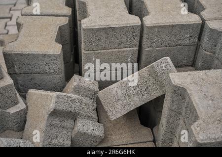 Pavimentazione di lastre impilate in un palo, processo di riparazione stradale, primo piano, focalizzazione selettiva sulle piastrelle, ricostruzione stagionale del marciapiede nei sentieri nei parchi Foto Stock