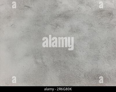 Un primo piano ad alta risoluzione di una parete grigia in cemento con macchie bianche nella struttura Foto Stock