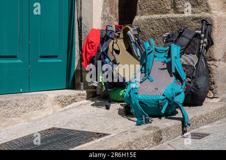 Zaini dei pellegrini accatastati alla porta di un ostello dei pellegrini sul Camino de Santiago. Foto Stock