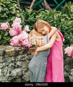 Ritratto all'aperto di due dolci bambine, bambini che giocano insieme nel giardino estivo Foto Stock