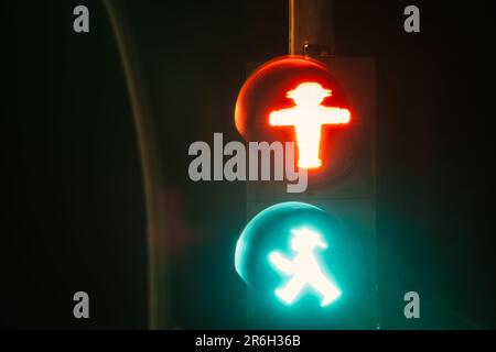 Un segnale di traffico rosso e blu intenso indica che i pedoni possono attraversare la strada in modo sicuro all'incrocio designato Foto Stock