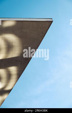 Primo piano di un edificio astratto che mostra il sole che getta ombre sulla sua superficie Foto Stock