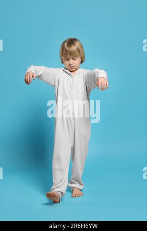 Ragazzo in pigiama che dorma su sfondo azzurro Foto Stock