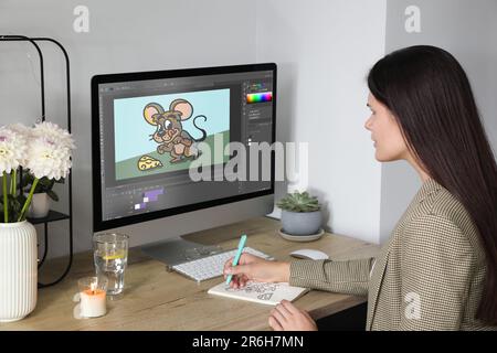 Animator che lavora alla tavola. Computer moderno con illustrazione sullo schermo Foto Stock