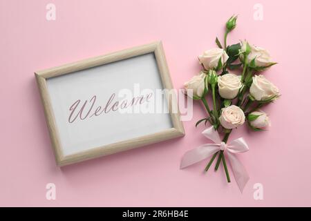 Carta di benvenuto. Belle rose e cornice con parola su sfondo rosa, piatto Foto Stock