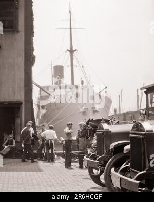 1930S GRUPPO DI UOMINI LONGSHOREMEN SUL LUNGOMARE MANGIARE PRANZO E PARLARE NAVE DA CARICO SULLO SFONDO NEW YORK HARBOR NYC USA - M3473 HAR001 NAVI HARS TRASPORTO MERCI DI MEZZA ETÀ B&W NORD AMERICA DI MEZZA ETÀ UOMO CARICO NORD AMERICA CAMION ABILITÀ OCCUPAZIONE COMPETENZE DI SCARICO UNION AUTOS ESTERNI SETTE NYC OCCUPAZIONI NEW YORK 7 AUTOMOBILI CITTÀ VEICOLI NEW YORK CITTÀ CARROZZA TRAINATA DA CAVALLI UOMO MEDIO-ADULTO CHE SPEDISCE IL LITORALE NERO E BIANCO DI ETNIA CAUCASICA HAR001 VECCHIO VASCELLO FASHIONED Foto Stock