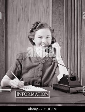 1940S SORRIDENTE RECEPTIONIST UFFICIO SEGRETARIA SEDUTA AL BANCO DI INFORMAZIONI CHE PARLA SUL TELEFONO CHE FA LE NOTE CHE GUARDANO LA MACCHINA FOTOGRAFICA - O522 HAR001 HARS STILE RECEPTIONIST ACCOGLIENZA COMUNICAZIONE CARRIERA GIOVANE ADULTO NOTE INFORMAZIONI ASSISTENTE FELICE GIOIA LIFESTYLE SODDISFAZIONE IMPIEGATO DONNE LAVORI STUDIO SHOT HEALTHINESS COMUNICAZIONE COPIA SPAZIO AMICIZIA SIGNORE PERSONE PROFESSIONE FIDUCIA B&W OCCHIO CONTATTO ABILITÀ PROFESSIONE FELICITÀ ABILITÀ TESTA E SPALLE ALLEGRIA SERVIZIO CLIENTI CAREERS HAIRSTYLE OFFICE WORKER AT ON OCCUPATIONS PHONES SMILES CONNECTION GAL FRIDAY PHONES ADMINISTRATOR GIOIOSO Foto Stock