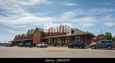 Medicine Hat, Alberta, Canada – 06 giugno 2023: Vista sulla strada della storica stazione ferroviaria in mattoni rossi del centro Foto Stock