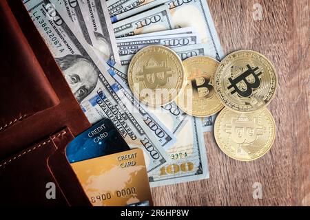 Bitcoins, banconote in dollari e portafoglio con carte di credito su sfondo di legno, piatto Foto Stock