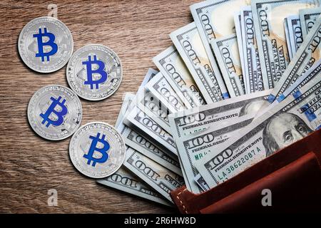 Bitcoins, banconote in dollari e portafoglio su sfondo di legno, piatto Foto Stock