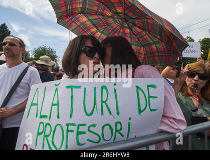 Bucarest, Romania. 9th giugno 2023: La gente mostra il proprio sostegno alla protesta degli insegnanti con cartelli che recita: "Siamo vicini agli insegnanti”. Quasi 12.000 dipendenti del sistema educativo, per lo più insegnanti, si dirigono lungo il tragitto tra la sede del governo rumeno e il Palazzo Presidenziale di Bucarest, nella terza settimana dello sciopero nazionale. Diverse federazioni sindacali dell'istruzione hanno iniziato uno sciopero nazionale il 22 maggio, chiedendo salari più alti e migliori condizioni di lavoro. Credit: Lucian Alecu/Alamy Live News Foto Stock