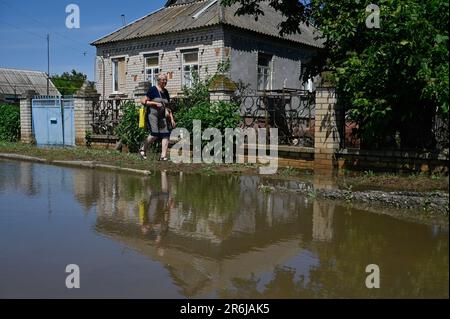 Chornobaivka, Ucraina. 09th giugno, 2023. Un residente locale visto camminare lungo una strada allagata nel villaggio di Chornobaivka vicino a Kherson. Il 6 giugno, l'esercito russo ha fatto esplodere la diga della centrale idroelettrica di Kakhovka, che ha causato un'alluvione diffusa nella regione di Kherson. (Foto di Sergei Chuzavkov/SOPA Images/Sipa USA) Credit: Sipa USA/Alamy Live News Foto Stock