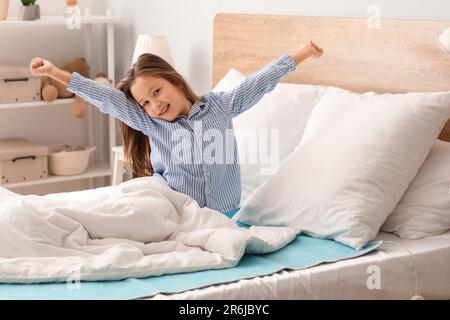 Bambina con riscaldamento elettrico che mostra pollice in su in camera da  letto di notte Foto stock - Alamy