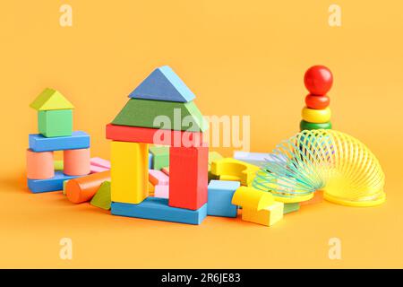 Diversi giocattoli colorati su sfondo arancione. Festa dei bambini Foto Stock