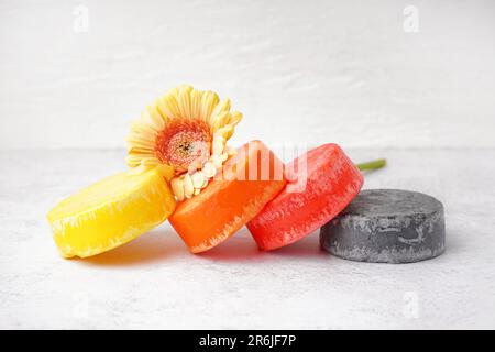 Diverso shampoo solido fatto a mano e fiore di calendula su sfondo chiaro, primo piano Foto Stock