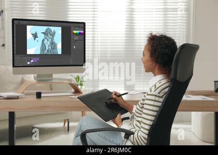 Animatore afroamericano con tablet grafico e computer. Illustrazione sullo schermo Foto Stock