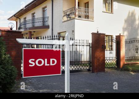 Rosso venduto segno vicino bella casa all'aperto Foto Stock