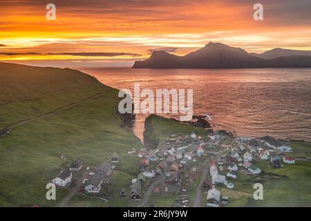 Cielo di fuoco all'alba sull'isola di Kalsoy e sul villaggio di Gjogv, vista dall'alto, Isola di Eysturoy, Isole Faroe, Danimarca, Europa Foto Stock
