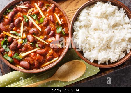 Rajma o Razma è un alimento popolare dell'India del nord, consistente dei fagioli rossi cotti del rene in un sugo spesso con le spezie servite con il riso vicino-in su un legnoso Foto Stock