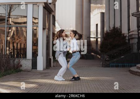Due ragazze stanno giocando l'una con l'altra sulla strada Foto Stock