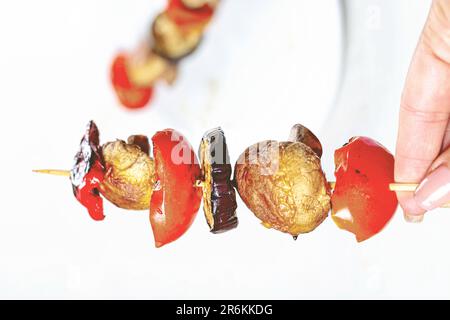 Immagine ravvicinata di uno spiedino di legno, con una varietà di verdure tra cui i peperoni, spiedato sul bastone Foto Stock