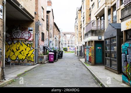 Londra, Regno Unito - Maggio 17 2023: Una strada secondaria a Shoreditch. La zona interna della città è coperta da graffiti e dietro c'è un ponte ferroviario. Foto Stock