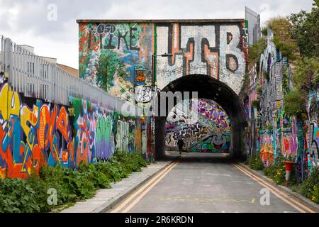 Londra, Regno Unito - Maggio 17 2023: Guardando verso un ponte ferroviario a Shoreditch. La grintosa area interna della città è coperta da graffiti. Foto Stock