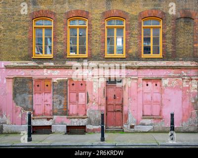 Londra, Regno Unito - Maggio 17 2023: Una vecchia casa Huguenot originale, con porte sbucciate, finestre e pareti in mattoni in Princelet Street a Spitalfields. Foto Stock