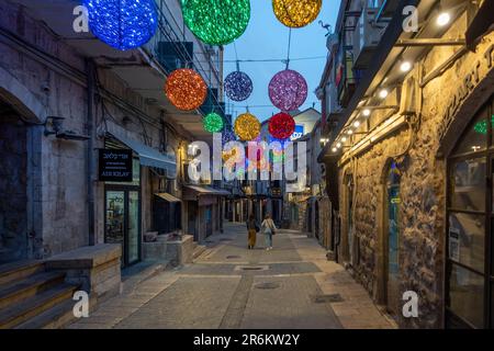 I pedoni camminano il venerdì sera attraverso Rivlin Street a Nahalat Shiva , che è stato il terzo quartiere costruito fuori della Città Vecchia di Gerusalemme nel 1860s. Gerusalemme ovest Israele Foto Stock
