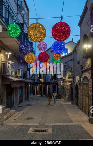 I pedoni camminano il venerdì sera attraverso Rivlin Street a Nahalat Shiva , che è stato il terzo quartiere costruito fuori della Città Vecchia di Gerusalemme nel 1860s. Gerusalemme ovest Israele Foto Stock