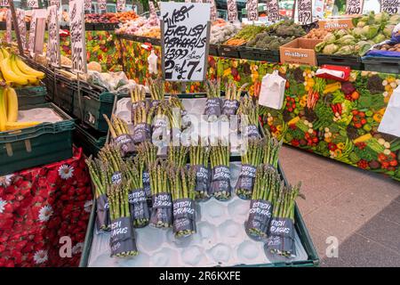 Asparagi inglesi in vendita su una bancarella del mercato dei fruttivori nel mese di giugno, Inghilterra, Regno Unito. Foto Stock