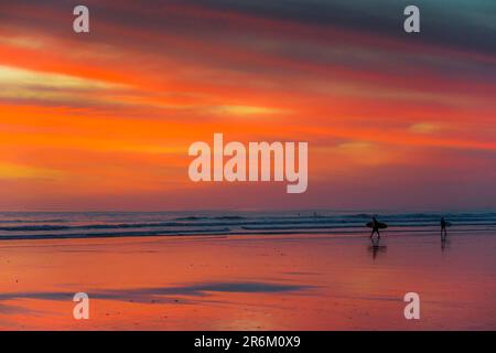 Surfista silhouette sulla spiaggia di Guiones, dove molti vengono a rilassarsi e surf al tramonto, Playa Guiones, Nosara, Guanacaste, Costa Rica, America Centrale Foto Stock