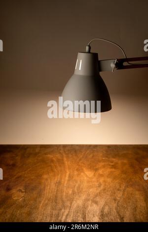 La lampada da scrivania illumina il luogo di lavoro sulla scrivania dell'ufficio Foto Stock