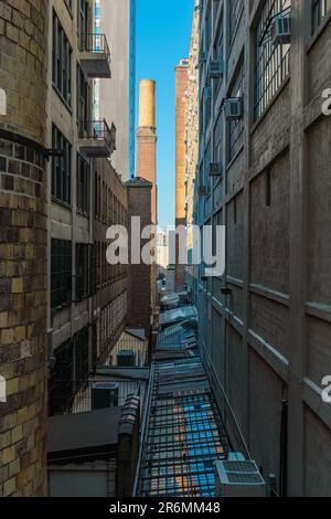 Un primo piano di un vicolo urbano tra due alti edifici in acciaio Foto Stock