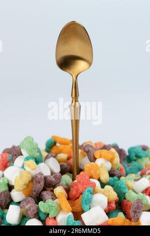 Il cucchiaio color oro proviene da una macrofite di cornflakes colorata vista ravvicinata Foto Stock