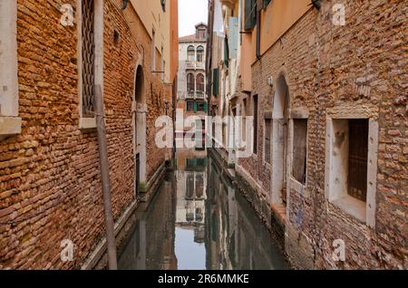 Intima Vista canale tra le mura residenziali di Venezia Foto Stock