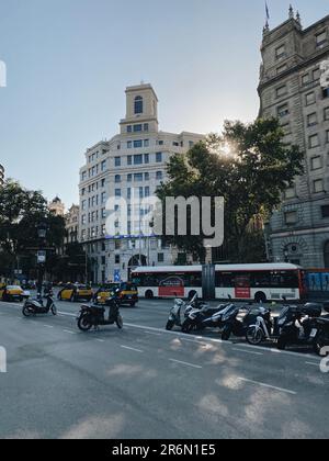 Una fila di motociclette in stile vintage parcheggiate nel centro storico di Barcellona, con un'architettura affascinante e strade acciottolate sullo sfondo Foto Stock