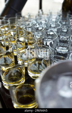 ci sono un sacco di vetri trasparenti con bevande. bevande versate all'evento. Foto Stock
