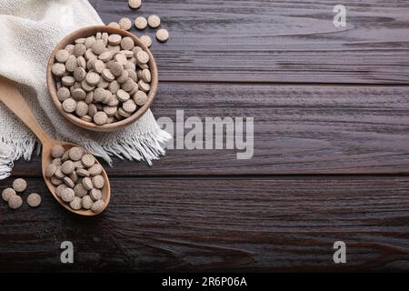 Composizione piatta con compresse di lievito di birra su tavola di legno. Spazio per il testo Foto Stock