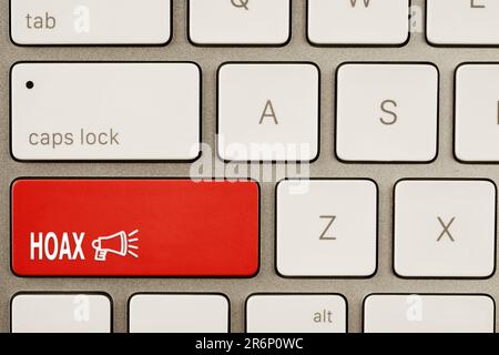 Pulsante rosso con parola Hoax e altoparlante sulla tastiera del computer, vista dall'alto Foto Stock